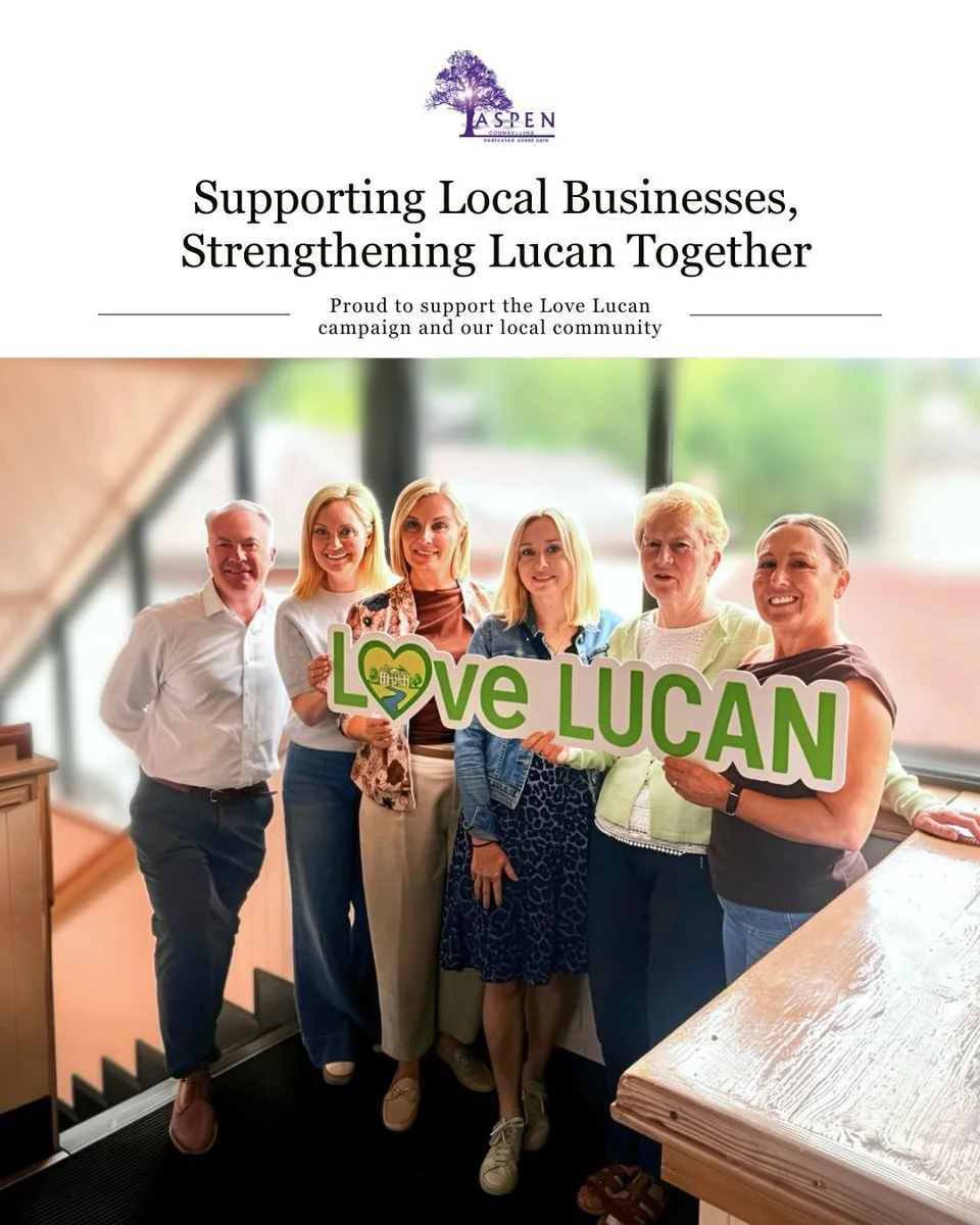 Group indoors holding a Love Lucan sign to support local businesses