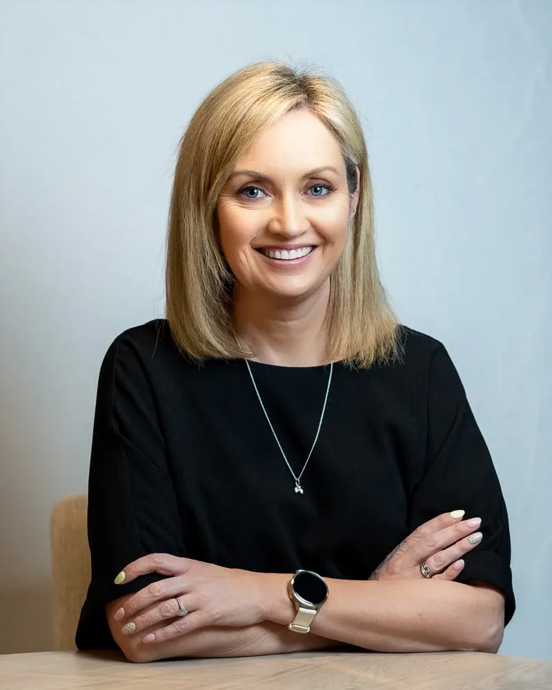 Vicki Casserly seated at a table with her arms folded